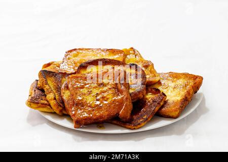 fette di pane tostato allo sciroppo su un piatto bianco su fondo bianco Foto Stock