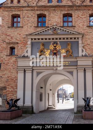 Statue del Drago sul lato dell'ingresso attraverso la porta di mattoni e con iscrizione, sigillo e stemma del consiglio, porta della città nel Vecchio Nord Foto Stock
