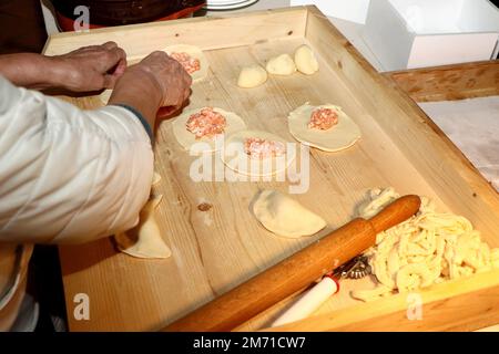 Donna prepara panzerotti pugliesi su una tavola di legno Foto Stock