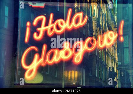 Hola Glasgow neon segno con tenement riflessione in finestra in spagnolo ciao Foto Stock