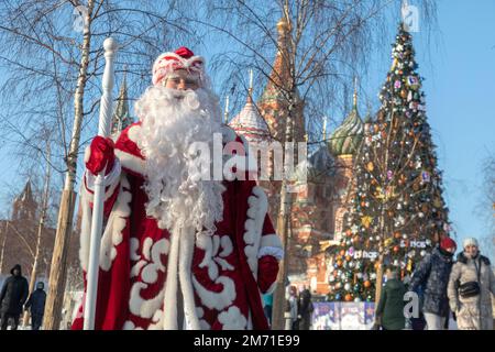 Mosca, Russia. 6th gennaio 2023. Padre Russo Frost (Ded Moroz) si trova sullo sfondo del Cremlino di Mosca e di San Basil's Cathedral nel centro di Mosca, Russia. Il 5-7 gennaio, Mosca ospita un evento dal titolo The Keepers of Winter Traditions, parte del festival annuale A Journey to Christmas, in cui si svolge Padre Frost di 14 regioni della Russia. Padre Frost è un equivalente russo di Babbo Natale. Nikolay Vinokurov/Alamy Live News Foto Stock