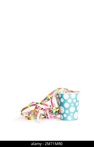 Una tazza monouso con streamer di carta colorata su sfondo bianco con spazio per le copie Foto Stock