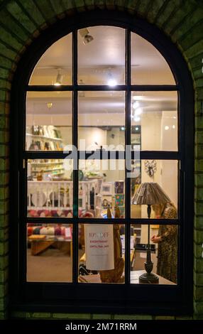 Vecchia vetrina ad arco di notte con cartello di vendita in Saffron Walden Foto Stock