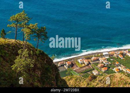 Vista elevata di Paul do Mar e della sua costa sull'Oceano Atlantico, presa dal sentiero escursionistico vicino al punto di osservazione "Miradouro da Raposeira", Madeira Foto Stock