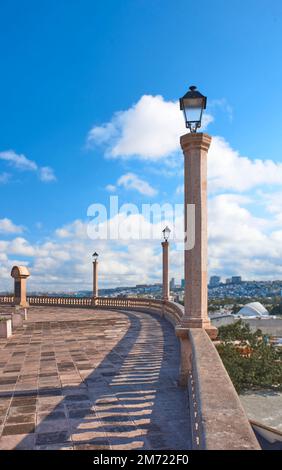 punto di vista di querétaro durante il giorno con cielo blu, con colonne in pietra e lampioni, nessuna gente Foto Stock