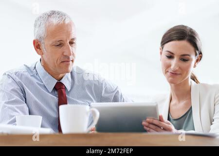 Tecnologia a supporto dei processi aziendali. due colleghi che utilizzano un tablet digitale al lavoro. Foto Stock