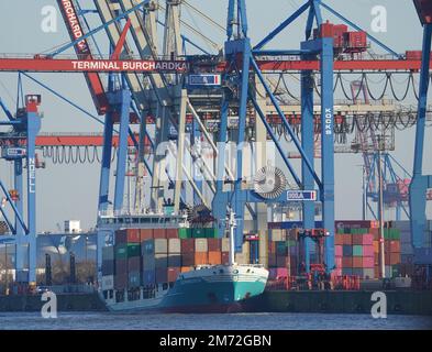 PRODUZIONE - 03 gennaio 2023, Amburgo: Una nave container viene caricata e scaricata al terminal dei container Burchardkai nel porto. Il porto di Amburgo sull'Elba è un porto universale per tutti i tipi di merci e di gran lunga il più importante luogo di movimentazione merci in Germania. Ogni anno, circa 130 milioni di tonnellate di merci di mare passano oltre i bordi del molo attraverso un buon 50 impianti di movimentazione, e circa 290 ormeggi offrono spazio per navi di tutte le dimensioni - da container e navi portarinfuse particolarmente grandi a petroliere e navi chimiche, navi di alimentazione e navi per vie navigabili interne. (A dpa 'il porto di Amburgo - Germ Foto Stock