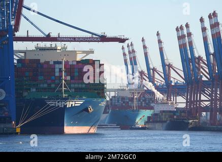 PRODUZIONE - 03 gennaio 2023, Amburgo: Le navi portacontainer vengono caricate e scaricate presso il terminal dei container Burchardkai (l) e il terminal dei container Eurogate (posteriore r) nel porto. Il porto di Amburgo sull'Elba è un porto universale per tutti i tipi di merci e di gran lunga il più importante luogo di movimentazione merci in Germania. Ogni anno, circa 130 milioni di tonnellate di merci di mare passano oltre i bordi del molo attraverso un buon 50 impianti di movimentazione, e circa 290 ormeggi offrono spazio per navi di tutte le dimensioni - da contenitori particolarmente grandi e navi portarinfuse, da petroliere e petroliere chimiche a navi di alimentazione e interne. (da a d Foto Stock