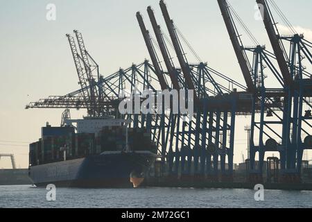 PRODUZIONE - 03 gennaio 2023, Amburgo: Una nave container della società di spedizioni Cosco Shipping viene caricata e scaricata presso il terminal container Tollerort nel porto. Il porto di Amburgo sull'Elba è un porto universale per tutti i tipi di merci e di gran lunga il più importante luogo di movimentazione merci in Germania. Ogni anno, circa 130 milioni di tonnellate di merci di mare passano oltre i bordi del molo attraverso un buon 50 impianti di movimentazione, e circa 290 ormeggi offrono spazio per navi di tutte le dimensioni - da contenitori particolarmente grandi e navi portarinfuse, da petroliere e petroliere chimiche a navi di alimentazione e interne. (a dpa ' Foto Stock