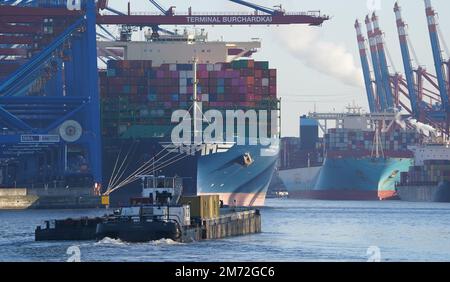 PRODUZIONE - 03 gennaio 2023, Amburgo: Le navi portacontainer vengono caricate e scaricate presso il terminal dei container Burchardkai (l) e il terminal dei container Eurogate (posteriore r) nel porto. Il porto di Amburgo sull'Elba è un porto universale per tutti i tipi di merci e di gran lunga il più importante luogo di movimentazione merci in Germania. Ogni anno, circa 130 milioni di tonnellate di merci di mare passano oltre i bordi del molo attraverso un buon 50 impianti di movimentazione, e circa 290 ormeggi offrono spazio per navi di tutte le dimensioni - da contenitori particolarmente grandi e navi portarinfuse, da petroliere e petroliere chimiche a navi di alimentazione e interne. (da a d Foto Stock