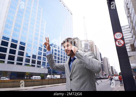 Taxi. Un breve scatto di un bel giovane uomo d'affari che salutava un taxi mentre parlava al telefono in città. Foto Stock