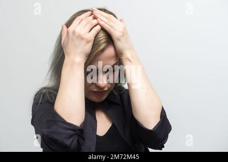 Triste stanco giovane donna che tocca la fronte avendo emicrania di emicrania o depressione di mal di testa, ragazza frustrata turbata con il tatto di problema la copertura sollecitata che grida Foto Stock