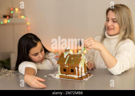 Madre e figlia che fanno casa biscotti di pan di zenzero, decorazione a casa, concetto di Natale Foto Stock