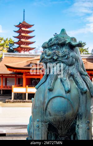 La statua del leone di bronzo nel Santuario di Itsukushima. Un santuario shintoista sull'isola di Itsukushima Giappone (popolarmente noto come Miyajima). Foto Stock