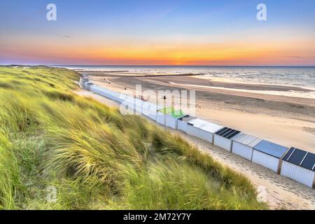 Case sulla spiaggia di Westkapelle viste dalle dune di Zeeland al tramonto, Paesi Bassi. Paesaggio scenario della natura in Europa. Foto Stock