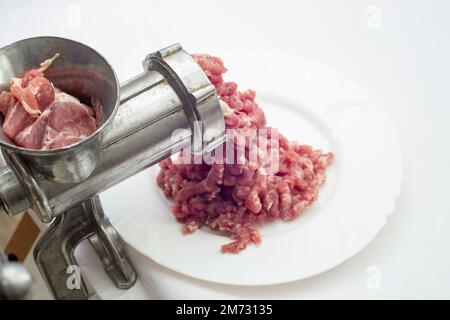 Carne di maiale macinata, carne macinata e un macinacaffè di metallo, primo piano morbido Foto Stock