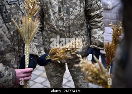 Non esclusiva: LVIV, UCRAINA - 6 GENNAIO 2023 - i militari ucraini tengono piccoli bouquet di avena e segale durante la cerimonia di installazione del principale C. Foto Stock