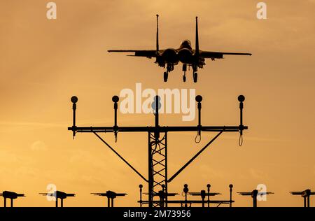 Getto da caccia al tramonto. Moderno jet militare con cielo arancione che ritorna da una missione di combattimento. Foto Stock