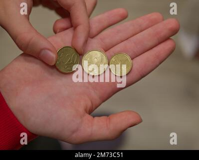 La ragazza tiene in mano monete in euro da 10 e 20 centesimi Foto Stock