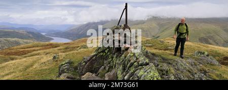 Walker alla cima del cairn su acciaio caduto, sopra Thirlmere nelle Fells centrali, Lake District National Park, Cumbria, Inghilterra, Regno Unito acciaio caduto è uno di Foto Stock