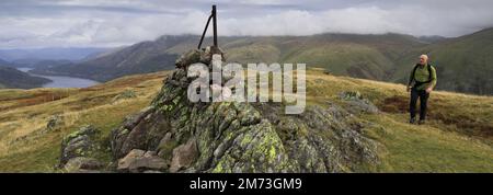 Walker alla cima del cairn su acciaio caduto, sopra Thirlmere nelle Fells centrali, Lake District National Park, Cumbria, Inghilterra, Regno Unito acciaio caduto è uno di Foto Stock