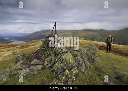 Walker alla cima del cairn su acciaio caduto, sopra Thirlmere nelle Fells centrali, Lake District National Park, Cumbria, Inghilterra, Regno Unito acciaio caduto è uno di Foto Stock