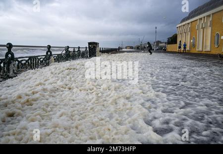 Brighton UK 7th Gennaio 2023 - Sea foam copre Hove lungomare Promenade come tempeste battere la costa meridionale oggi con forti venti e pioggia : Credit Simon Dack / Alamy Live News Foto Stock