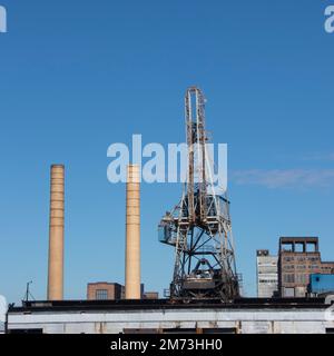 Grande gru industriale sul lungomare del Mississippi sorge accanto a due grandi camini da fumo e raffineria di zucchero industriale semi abbandonata Foto Stock