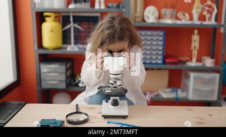 Adorabile ragazza caucasica studente utilizzando il microscopio in classe Foto Stock