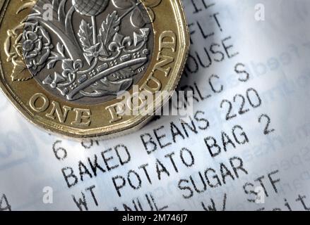 CIBO SHOPPING RICEVUTA CON UNA MONETA DA UNA LIBBRA RE RE RE COSTO DELLA VITA CRISI PREZZI DI BASE DEL NEGOZIO AUMENTO DEI COSTI DI BILANCIO DELLE FAMIGLIE ECC UK Foto Stock