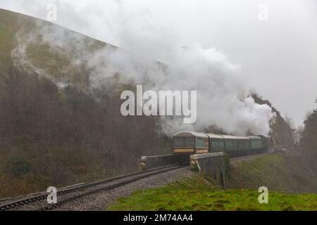 Corfe Castle Dorset, Regno Unito. 7th gennaio 2023. Inverno Warm Up nostalgico evento si svolge durante il fine settimana con una miscela di treni passeggeri a vapore e diesel che viaggiano tra Swanage e Norden. 34070, Manston, treno a vapore viaggia attraverso la splendida campagna del Dorset passando attraverso il castello di Corfe in una giornata grigia umida e ventosa. Credit: Carolyn Jenkins/Alamy Live News Foto Stock