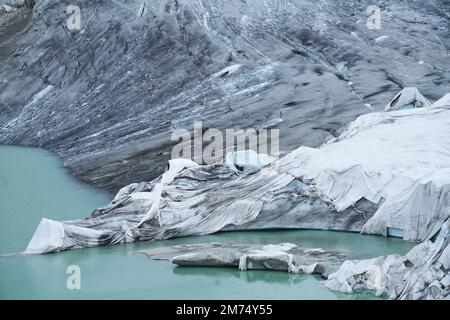 Lo scioglimento del ghiacciaio del Rodano è il segno più visibile del cambiamento climatico. A causa delle alte temperature, i fogli bianchi non possono più proteggere il ghiacciaio Foto Stock