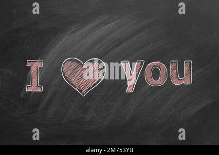 Ti voglio bene. Iscrizione in gesso sulla lavagna della scuola. San Valentino. Concetto di amore. Foto Stock