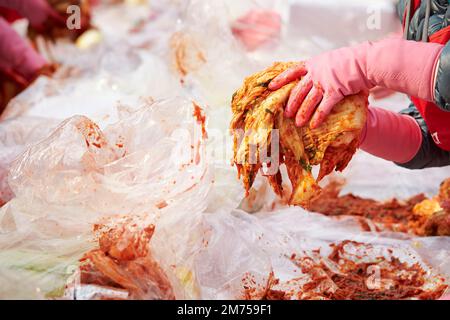 Primo piano delle mani che fanno il kimchi Foto Stock