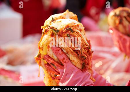 Primo piano delle mani che fanno il kimchi Foto Stock