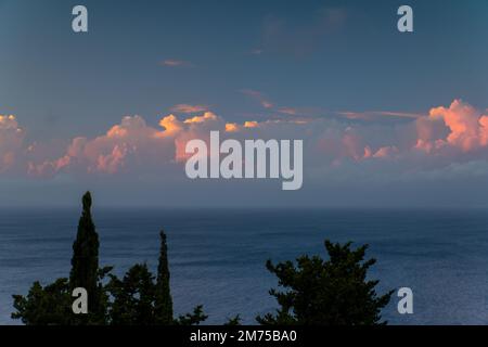 Nuvole rosa al tramonto sul Mar Ionio da Paxos, Grecia Foto Stock
