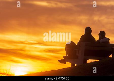 Wien, Vienna: Tramonto di fiery, 2 uomini seduti sulla panchina, persone come silhouette nel 19. Döbling, Vienna, Austria Foto Stock