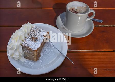 Strudel di mele con crema e una tazza di cappuccino servito in una caffetteria, Baviera, Germania Foto Stock