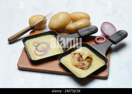 Raclette, formaggio a raclette fuso in padelle e ingredienti Foto Stock