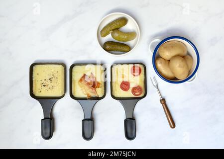 Raclette, formaggio a raclette fuso in padelle e ingredienti Foto Stock