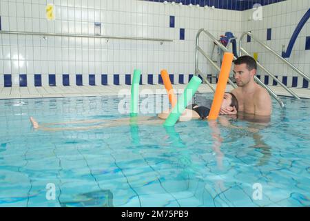 marito e moglie incinta fanno esercizi in acqua Foto Stock