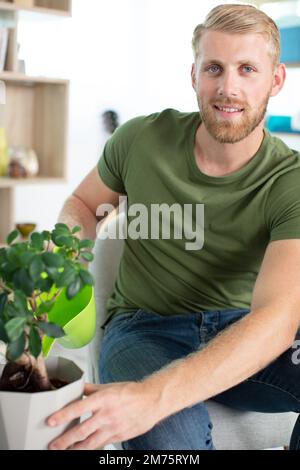 uomo europeo che lavora e si prende cura degli impianti Foto Stock