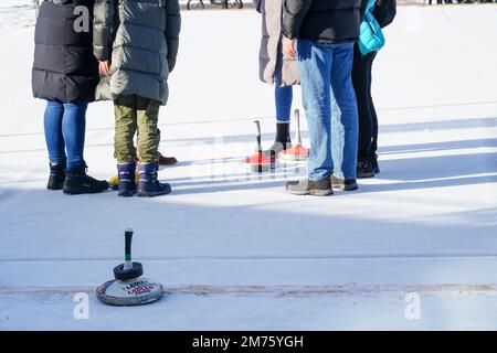 Seefeld, Austria - Dicembre 2022: Una famiglia ama fare una partita di curling sul ghiaccio nella località sciistica di Seefeld in Tirolo, Austria Foto Stock