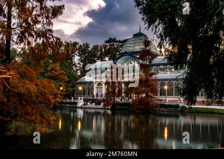 tramonto sul palazzo di cristallo con i riflessi nel lago nella città di madrid Foto Stock