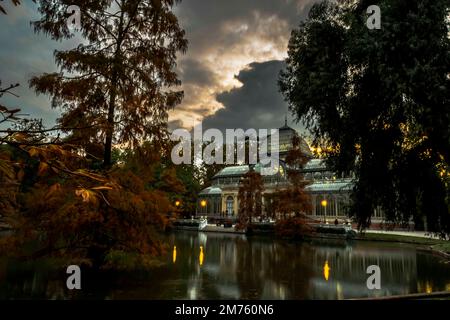 tramonto sul palazzo di cristallo con i riflessi nel lago nella città di madrid Foto Stock