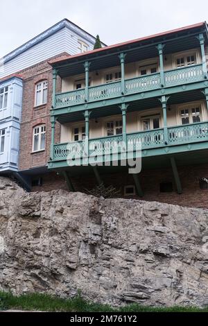 Tradizionali case georgiane colorate con balconi scolpiti sulla roccia nella zona storica di Abanotubani a Tbilisi, Georgia Foto Stock