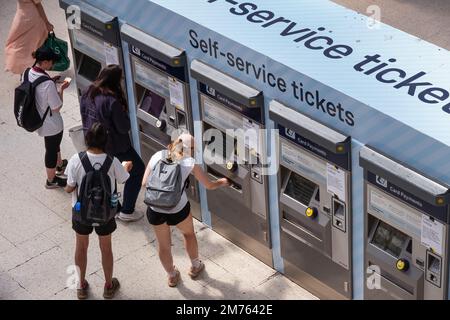 Persone che acquistano i biglietti da distributori automatici di biglietti all'interno della stazione di Waterloo Foto Stock