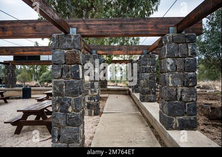 Area picnic con tavoli e panchine. Tetto decorativo su pilastri in pietra. Luogo di riposo. Foto Stock