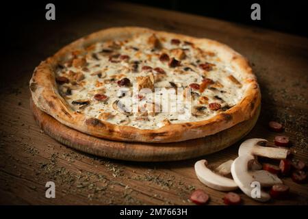 deliziosa pizza di pollo con salsicce e funghi. Foto Stock