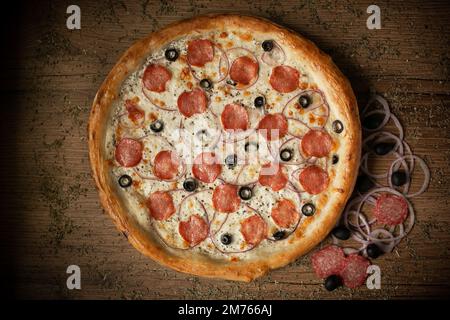 deliziosa pizza di pollo con salsicce e funghi. sfondo tavolo di legno scuro Foto Stock